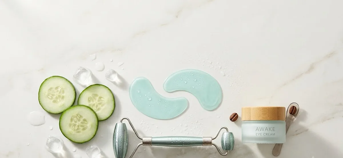 Flat lay beauty con patch in idrogel, fette di cetriolo e cubetti di ghiaccio: rimedi per le borse sotto gli occhi